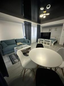 a living room with a white table and a couch at Promenada Apartments in Năvodari