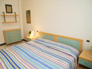 1 dormitorio con 1 cama con un colorido edredón a rayas en Condominio Frontemare, en Grado