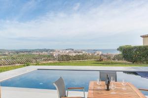 a patio with a table and a swimming pool at Villa Saramel con vistas panorámicas al mar in Sant Antoni de Calonge
