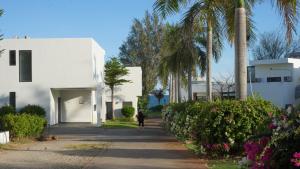 una persona caminando por una acera junto a un edificio blanco en Dreamers House Vung Tau - a beachfront villa, en Vung Tau 30 fotos más
