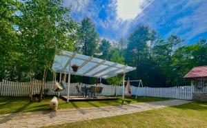 a pavilion with a swing in a yard at Casuta cu amintiri in Cîmpulung