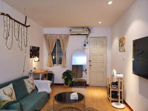 - un salon avec un canapé vert et une télévision dans l'établissement Tiny Homes- Vintage Apartments, à Hanoï