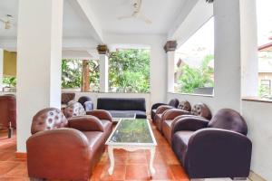 a waiting room with leather chairs and a table at FabHotel Prime Fair stayz in Goa