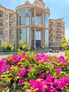 een groot gebouw met roze bloemen ervoor bij Ramage Hotel & Resort in Caïro