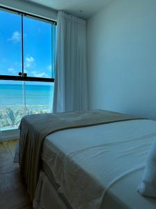 1 dormitorio con cama y ventana grande en Pousada Aloha, en Maceió
