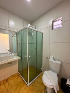 een badkamer met een douche, een toilet en een wastafel bij Pousada Aloha in Maceió