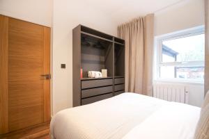 1 dormitorio con cama y ventana en Smithfield by The Heim Residences, en Mánchester