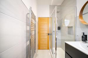 y baño con ducha, lavabo y espejo. en Smithfield by The Heim Residences, en Mánchester
