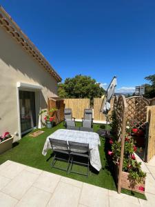 patio con tavolo e sedie sull'erba di l’Anita a Théoule-sur-Mer