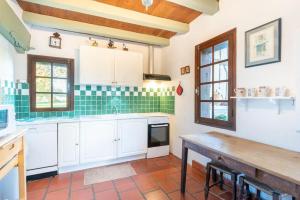 una cocina con armarios blancos y azulejos verdes en Maison de maître landaise, Bastide d'Armagnac en Lacquy