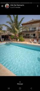 a picture of a swimming pool in front of a house at la villa sur la plage in Palmarin