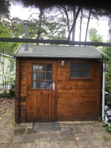 a wooden shed with a door and a window at Goolderheide De Bochel 542 in Bocholt