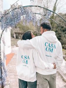 a man and a woman standing under an arch with flowers at Casa Om in Dosríus