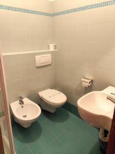 La salle de bains est pourvue de toilettes et d'un lavabo. dans l'établissement Hotel Il Guscio, à Grado