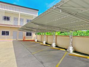awning over a parking lot in front of a building at โรงแรม ปาล์มเพลส in Ban Wang Phai Tha Kham