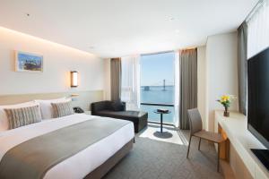 a hotel room with a large bed and a window at Hotel Centralbay in Busan
