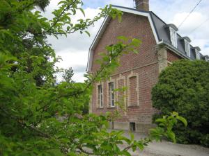an old brick building with trees in front of it at Le Clos Boutenelle in Éperlecques