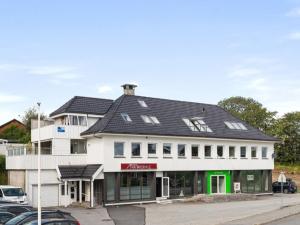 un bâtiment blanc avec un toit noir dans l'établissement Leilighet i Nærbø sentrum, à Narbø