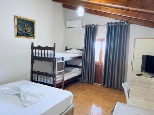 1 dormitorio con 1 cama y TV. en Molla Hotel Restorant, en Shëngjin