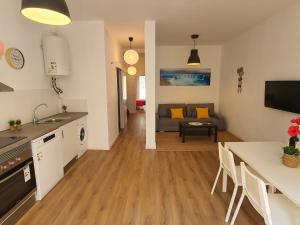 eine Küche und ein Wohnzimmer mit einem Tisch und einem Sofa in der Unterkunft Apartments Gaudi Barcelona in Barcelona