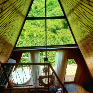 a large window in a room with a staircase at Wayside Cottage in Batumi