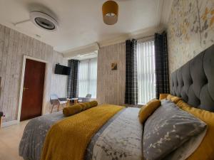 a bedroom with a large bed with a yellow blanket at Daffodil Guest House in Filey