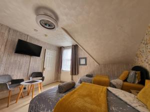 1 dormitorio con 1 cama y TV en la pared en Daffodil Guest House, en Filey