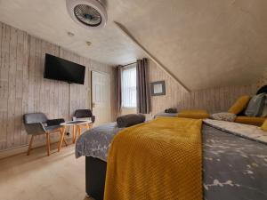a bedroom with a bed and a flat screen tv at Daffodil Guest House in Filey