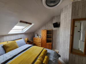 una camera con letto, cassettiera e specchio di Daffodil Guest House a Filey