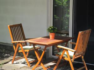 een houten tafel en 2 stoelen op een veranda bij Hotel Sonne in Bad Homburg vor der Höhe