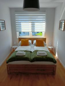 um quarto com uma cama com duas almofadas e uma janela em Allewidok 2 em Jelenia Góra
