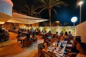 people sitting at tables in a restaurant at night at Pacha Hotel in Ibiza Town