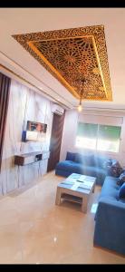 a living room with a blue couch and a table at Prestigieux Appart-Hôtel Luxury in Kenitra
