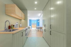 a kitchen with white cabinets and a sink at Newly renovated studio 2 min from Playa La Arena in Puerto de Santiago