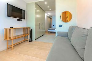 a living room with a couch and a flat screen tv at Newly renovated studio 2 min from Playa La Arena in Puerto de Santiago