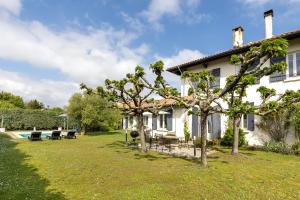 a house with a yard with trees and a pool at Villa Julien in Saint-Julien-en-Born