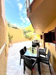un patio con mesa y sillas en Oelia Rooms & Apartments en Agia Marina Aegina