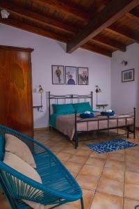 1 dormitorio con 1 cama, 1 silla y 1 sofá en Funtana'e Mari en Gonnesa