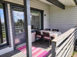 un patio con mesa y sillas en un porche en Tilava kaksio paritalosta, en Kangasala