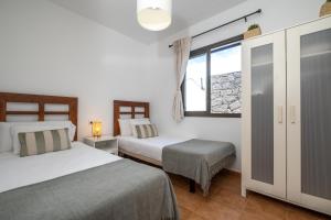 Un dormitorio con dos camas y una ventana. en Casa Rosa, en Playa Blanca 37 fotos más