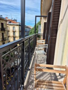 a balcony with two wooden benches on a building at Pension Joakina in San Sebastián