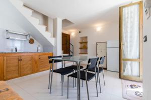 a kitchen with a glass table and black chairs at Spiaggia e relax in Calasetta