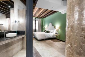 格拉纳达Hotel Casa Palacete Tablas的一间卧室设有绿色的墙壁、一张床和一个水槽