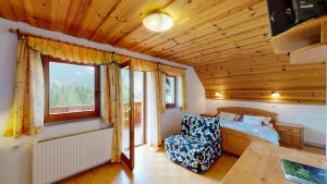 1 dormitorio con 1 cama y 1 silla en una habitación en Tourist farm Gradišnik en Solčava