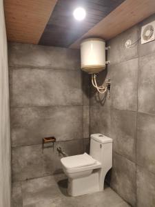 łazienka z toaletą i lampką na ścianie w obiekcie La Familia Kasol w mieście Kasol