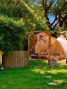 a tent in a yard next to a fence at Le Pavillon Vert - B&B in Vedène