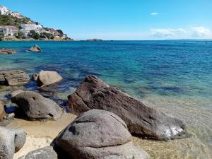 a beach with some rocks in the water at Escapades ensoleillées Climatisation Télévision in Sigean