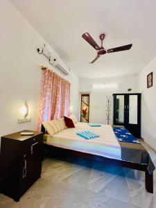1 dormitorio con 1 cama y ventilador de techo en Marari kallyani beach homestay, en Mararikulam