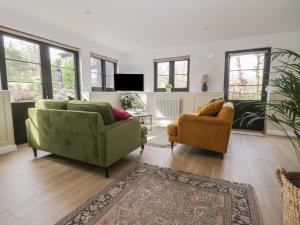 a living room with two chairs and a couch at Cherry Orchard Farm in Maidstone