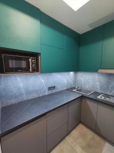 a kitchen with a microwave and a sink at 2 separate bedrooms apartment in Lviv